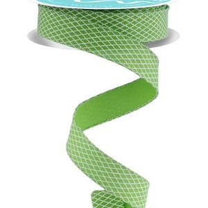 May include: A spool of green ribbon with a white diamond pattern. The ribbon is unrolled, revealing a solid green underside. The spool has a teal label with white text. Perfect for crafting and gift wrapping.