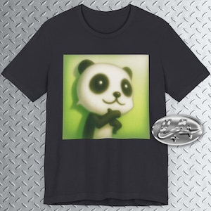 May include: A dark gray t-shirt featuring a cartoon panda bear with a white face, black ears, and black arms. The panda is set against a green background. A silver emblem is on the right side of the shirt.