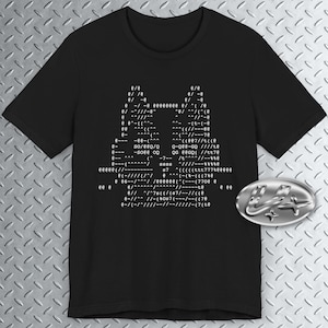 Op de afbeelding: Zwart T-shirt met een wit grafisch ontwerp van een codepatroon. De code bevat de tekst "SORE 00" en "807//((.