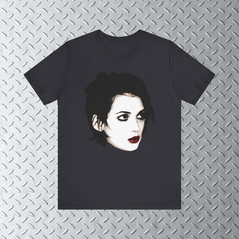 Pode incluir: Uma camiseta preta com uma estampa gr&aacute;fica de uma mulher com cabelo escuro e batom vermelho. A mulher est&aacute; olhando para a direita.