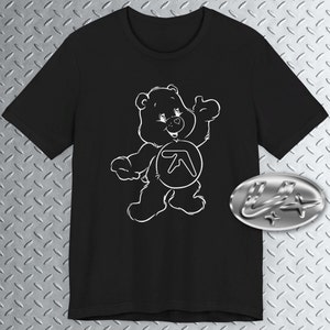 May include: Black t-shirt with a white outline of a Care Bear wearing a white circle with the letter "A" inside. The Care Bear is waving with its right paw.