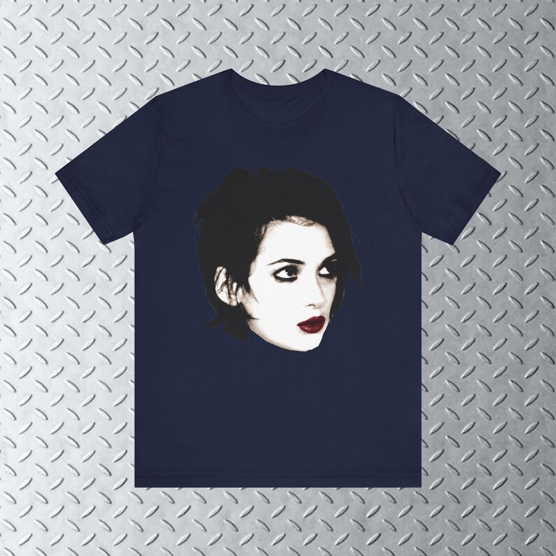 Pode incluir: Uma camiseta azul marinho com uma imagem em preto e branco de uma mulher com cabelo escuro e batom vermelho.