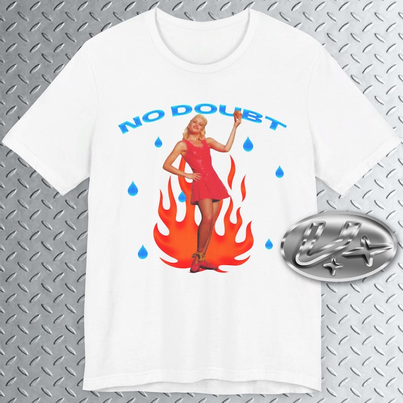 May include: White t-shirt with a graphic of a woman in a red dress standing in flames with blue raindrops falling around her. The text "NO DOUBT" is printed in blue above the graphic.