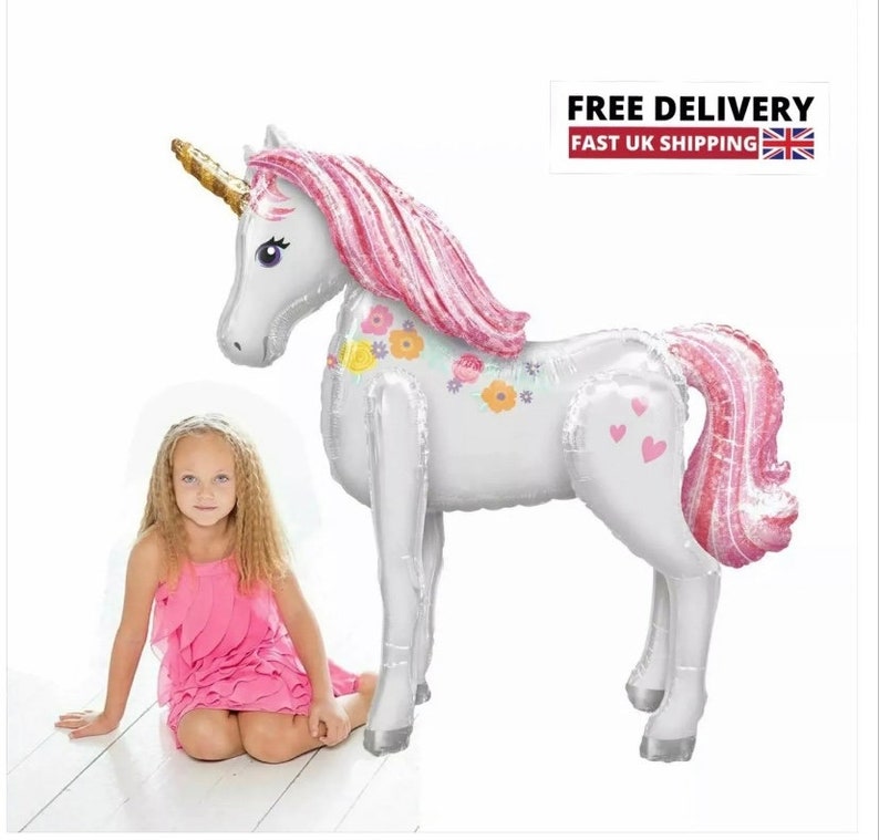 May include: A large white unicorn balloon with pink mane and tail, decorated with flowers. The balloon is standing on a white surface.