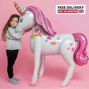 May include: A large white unicorn balloon with pink glitter accents and floral details. The balloon has a gold horn and pink glitter mane and tail.
