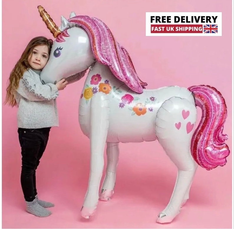 May include: A large white unicorn balloon with pink glitter accents and floral details. The balloon has a gold horn and pink glitter mane and tail.