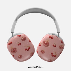Puede incluir: Auriculares blancos y plateados con almohadillas con un patrón de cerezas rojas y bolas de discoteca sobre un fondo rosa. El texto "AesthePoint" está en la parte inferior.