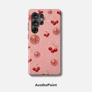 Peut inclure: Une coque de téléphone rose avec un motif de cerises et de boules disco. L'étui a une finition brillante et le texte "AesthePoint" en bas.
