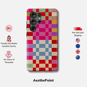 Op de afbeelding: Een kleurrijke telefoonhoes met een geometrisch dambordpatroon in roze, rood, blauw, geel en groen. De hoes heeft een cameramodule en de tekst "AesthePoint" onderaan.