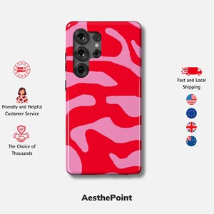 May include: A red and pink patterned phone case with an abstract design. The case features a vibrant combination of red and light pink, creating a striking visual effect. The phone case has a camera module with multiple lenses.