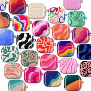 Puede incluir: Una colección de fundas para AirPod de colores con varios diseños abstractos. Las fundas presentan una gama de colores, incluyendo rosa, naranja, azul, verde y negro, con patrones como remolinos y ondas. Cada funda tiene un pequeño lazo para sujetar a un llavero.