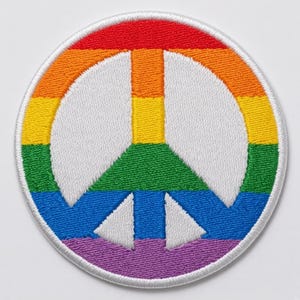 Peut inclure: Un écusson brodé circulaire présentant un symbole de paix blanc centré sur un fond arc-en-ciel horizontal. Les rayures arc-en-ciel se composent de fils rouge, orange, jaune, vert, bleu et violet, avec une bordure cousue blanche.