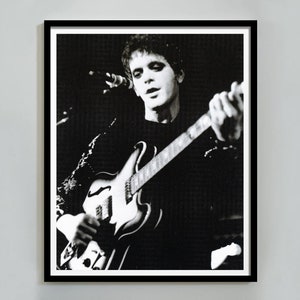 Puede incluir: Fotografía en blanco y negro de un músico tocando la guitarra en un escenario.