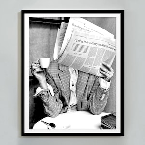 May include: A person wearing a checked blazer sits at a table, holding a cup of coffee and reading a newspaper. The newspaper headline reads "April in Paris of Hadlyme North School".