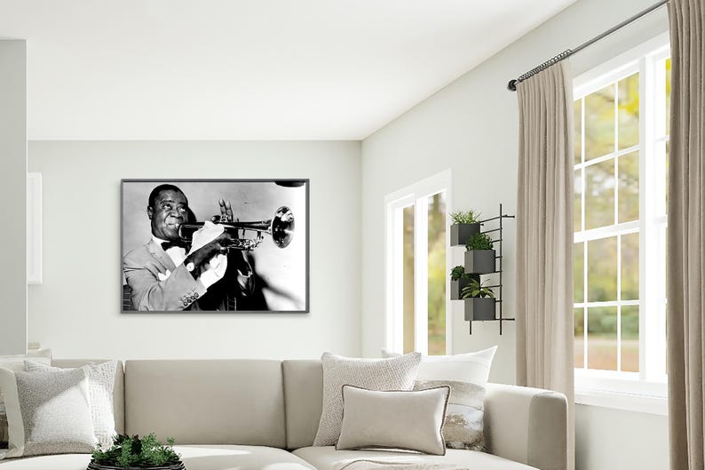 May include: Black and white photograph of a man playing a trumpet. The man is wearing a suit and bow tie. The photograph is framed in a black frame.