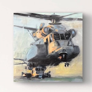 May include: A painting of a gray military helicopter with a yellow and orange sunset in the background. The helicopter is in mid-air and has a smaller helicopter attached to the bottom.