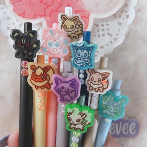 handmade, pixel poke eeveelution pens, eevee flareon volteon Vaporeon umbreon espeon leafeon glaceon sylveon