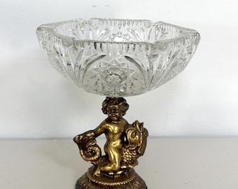 Bol o soporte para aperitivos de cristal tallado estilo Hollywood Regency vintage con querubines de latón sobre un soporte con forma de pez, 19 cm de diámetro x 21 cm de alto.