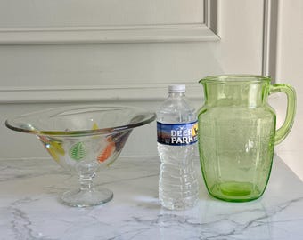 Puede elegir entre un cuenco de vidrio artístico con pie y hojas de colores de 9,75" x 5,5" o una jarra de vidrio verde uranio Anchor Hocking de la década de 1950 de 8" x 6,5".