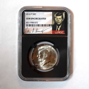 May include: A silver half dollar coin featuring John F. Kennedy's profile, the words "In God We Trust" and "2016" are visible. The coin is encased in a black plastic holder with a white label that reads "2016 P 50C GEM UNCIRCULARED 4511988-072 NGC".