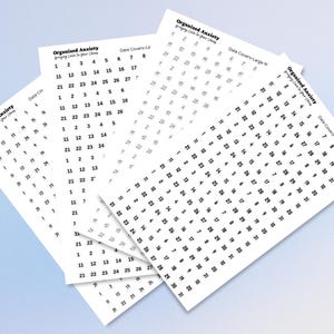 May include: Four white rectangular sheets featuring black printed calendar date covers. Each sheet displays the text Organized Anxiety Bringing Calm To Your Chaos and various numerical sequences ranging from 1 to 31 in different layouts.