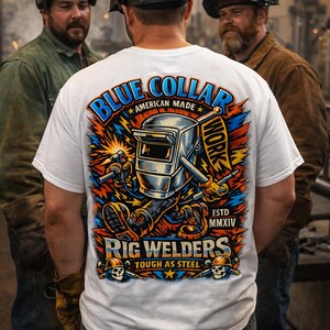 May include: White t-shirt with a colorful graphic featuring a welding mask, sparks, and the words "Blue Collar American Made" and "Rig Welders Tough as Steel." The shirt is worn by a person standing with two other people wearing welding helmets.