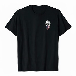 May include: Black t-shirt featuring a small graphic of a skull wearing a white hard hat and a face covering with an American flag design. The skull graphic is centered on the chest of the shirt.