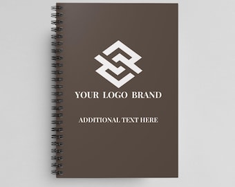 May include: A brown spiral bound notebook with a white geometric logo and the text "YOUR LOGO BRAND" and "ADDITIONAL TEXT HERE".