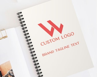 May include: A white spiral notebook with a red logo of two overlapping "W" letters. The text "CUSTOM LOGO" and "BRAND TAGLINE TEXT" is printed below the logo.