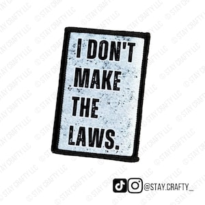 May include: A rectangular patch with the text "I DON'T MAKE THE LAWS." in bold black letters. The background is a speckled white and gray. The patch has a black border and the words "STAY CRAFTY LLC" are watermarked on the image.