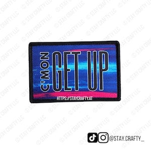 May include: A rectangular patch with the words "C'MON GET UP" in white, outlined in black, on a blue and pink striped background. The patch has a black border and the website address "HTTPS://STAYCRAFTY.AT" is at the bottom.