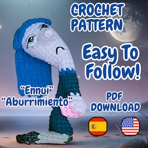 Puede incluir: Patrón de crochet para un personaje amigurumi azul y blanco con las palabras "Ennui" y "Aburrimiento" en la imagen. El patrón está disponible para descargar en PDF. La imagen también incluye banderas de España y Estados Unidos.