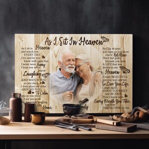 May include: A wooden sign with a photo of an older couple, a butterfly design, and the text "As I Sit In Heaven" and "So Live You Life".
