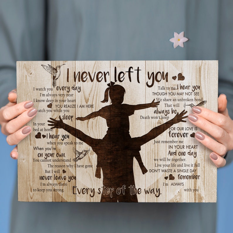May include: A wooden sign with a silhouette of a father carrying a child on his shoulders. The sign has a wood grain background and features a hummingbird and the text "I never left you. Every step of the way." The text also includes a message about love, loss, and remembering a loved one.