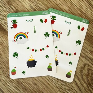 May include: Two sheets of St. Patrick's Day stickers with various festive designs. The stickers include leprechauns, rainbows, shamrocks, pots of gold, cupcakes, and decorative banners. The text "Pinned To TheFridge.com" is at the bottom.
