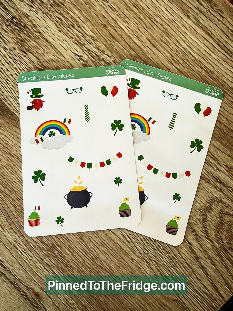 May include: Two sheets of St. Patrick's Day stickers with various festive designs. The stickers include leprechauns, rainbows, shamrocks, pots of gold, cupcakes, and decorative banners. The text "Pinned To TheFridge.com" is at the bottom.
