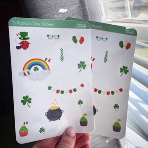 May include: Two sticker sheets with St. Patrick's Day themed designs. The stickers include a leprechaun, rainbow, shamrocks, pot of gold, cupcakes, and balloons. The text "Pinned ToTheFridge.com" is at the bottom.