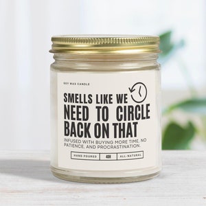 以下が含まれることがあります： 白いラベルに「Smells like we need to circle back on that. Infused with buying more time, no patience, and procrastination. Hand poured 40h All-natural.」と書かれた大豆ワックスキャンドル
