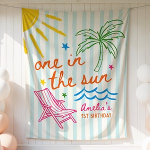 Może przedstawiać: Baner o tematyce plażowej z napisem "one in the sun" i "Amelia's 1st Birthday". Baner przedstawia słońce, palmę, leżak i fale. Po obu stronach znajdują się balony w kolorze białym i brzoskwiniowym.