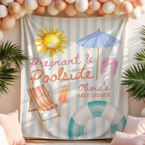 May include: A baby shower backdrop with a beach theme, featuring a sun, umbrella, and beach chair illustrations. The backdrop reads "Pregnant & Poolside Olivia's BABY SHOWER" with a blue and white striped background. Balloons and pillows surround the backdrop.
