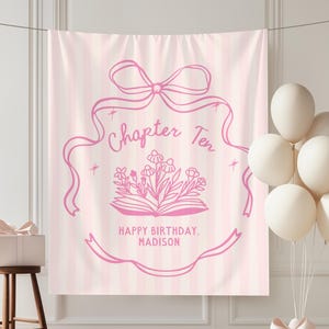 May include: A pink and white striped backdrop with a pink floral design and the text "Chapter Ten Happy Birthday, Madison." The backdrop is decorated with a bow, balloons, and a gift box.