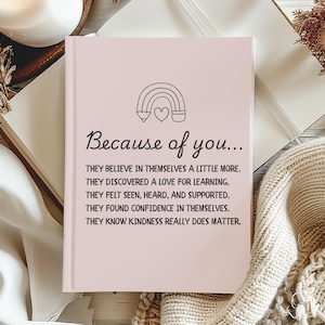 Op de afbeelding: Een roze notitieboek met een regenboog- en hartontwerp. De tekst op het notitieboek luidt "Because of you... They believe in themselves a little more. They discovered a love for learning. They felt seen, heard, and supported. They found confidence in themselves. They know kindness really does matter."