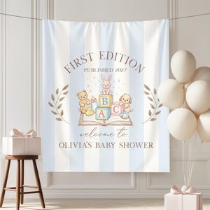 Könnte beinhalten: Babyparty-Banner mit blau-weißen Streifen, Text "FIRST EDITION PUBLISHED 2027" und "welcome to OLIVIA'S BABY SHOWER". Es zeigt Illustrationen von Babyspielzeug und Ballons.