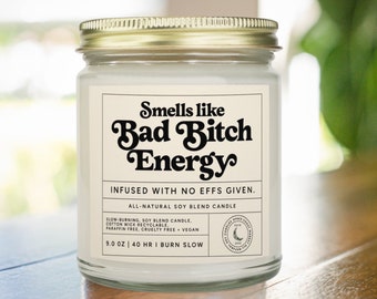 Può includere: Un barattolo di vetro bianco per candele con un coperchio dorato. L'etichetta recita "Smells like Bad Bitch Energy" e "Infused with no effs given." La candela è a base di miscela di soia naturale, a combustione lenta e vegana. Ha un peso di 9,0 oz e una durata di 40 ore.