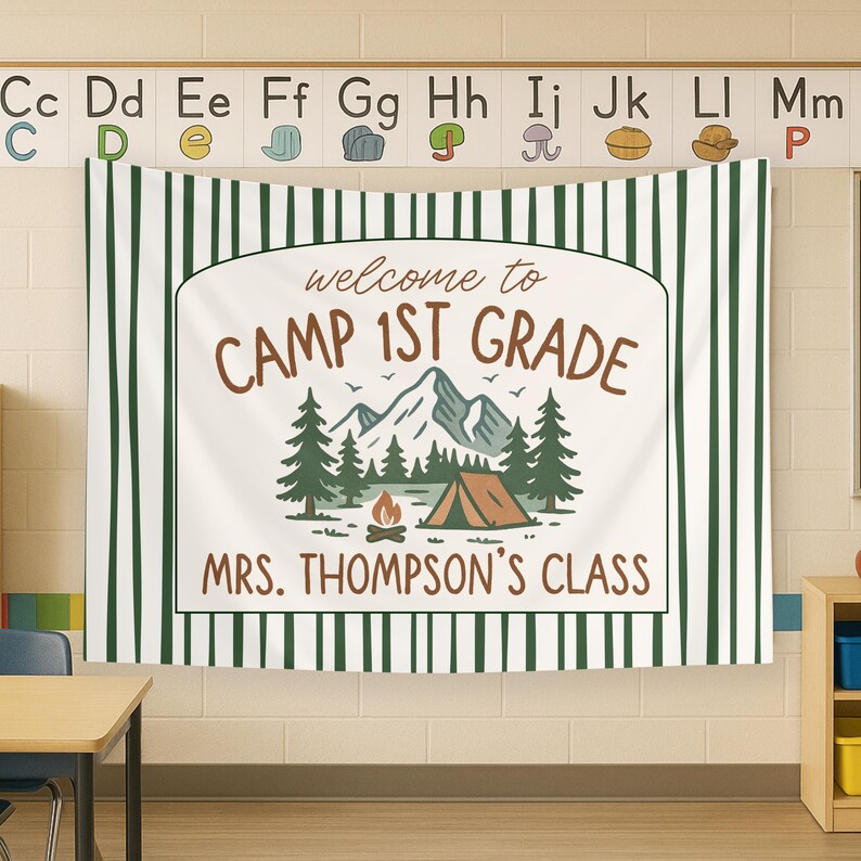 May include: A white banner with green stripes, featuring a camping theme. The banner reads "Welcome to Camp 1st Grade" and "Mrs. Thompson's Class". The banner has a graphic of a tent, mountains, trees, and a campfire.