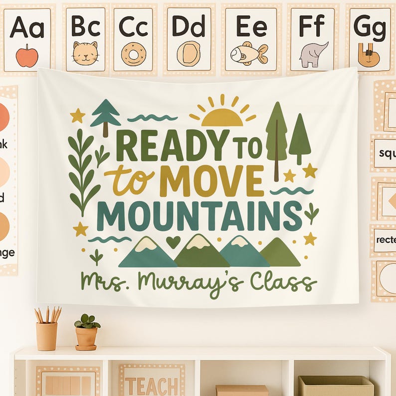 May include: A white canvas banner with green and gold text that reads "READY TO MOVE MOUNTAINS" with a green mountain range and a yellow sun. The banner also includes the text "Mrs. Murray's Class".