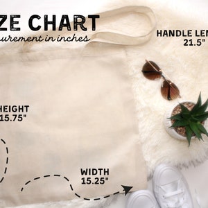 May include: A beige canvas tote bag with black stitching and a size chart in inches. The bag is 15.75 inches tall, 15.25 inches wide, and has a handle length of 21.5 inches.