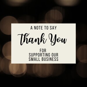 May include: A note card with a white background and black text that says "A note to say thank you for supporting our small business". The background is a blurry image of brown and gold bokeh lights.