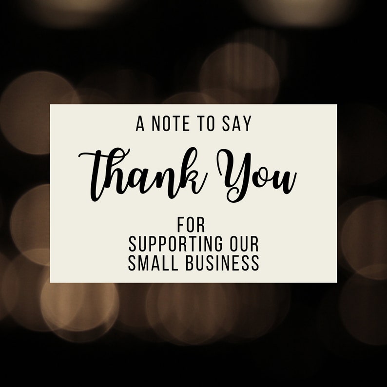 May include: A note card with a white background and black text that says "A note to say thank you for supporting our small business". The background is a blurry image of brown and gold bokeh lights.
