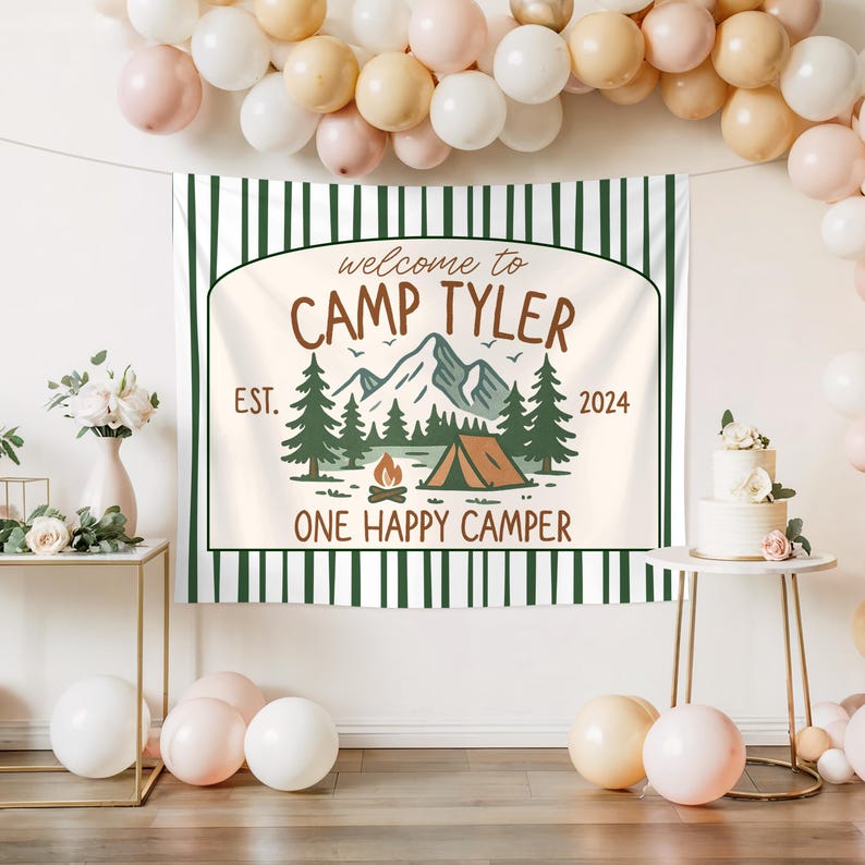May include: A white and green striped banner with the text "Welcome to Camp Tyler Est. 2024 One Happy Camper" and a graphic of a mountain range, a tent, and a campfire.